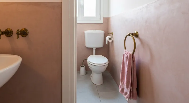 Aseo pequeño con microcemento rosado y grifería vintage en Mataró