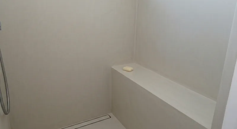 Banco de ducha en microcemento integrado en la pared en Manresa