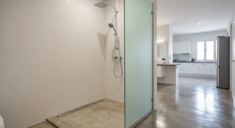 Ducha walk-in con microcemento gris y nicho integrado en Badalona